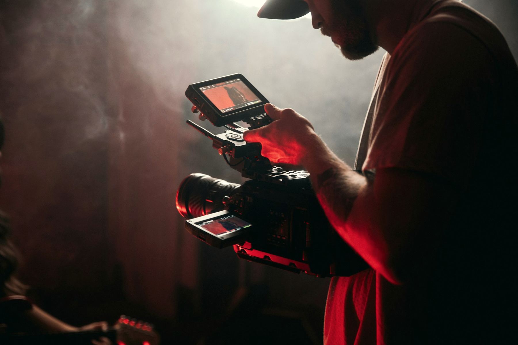 Camera operator with a cinema camera under red light