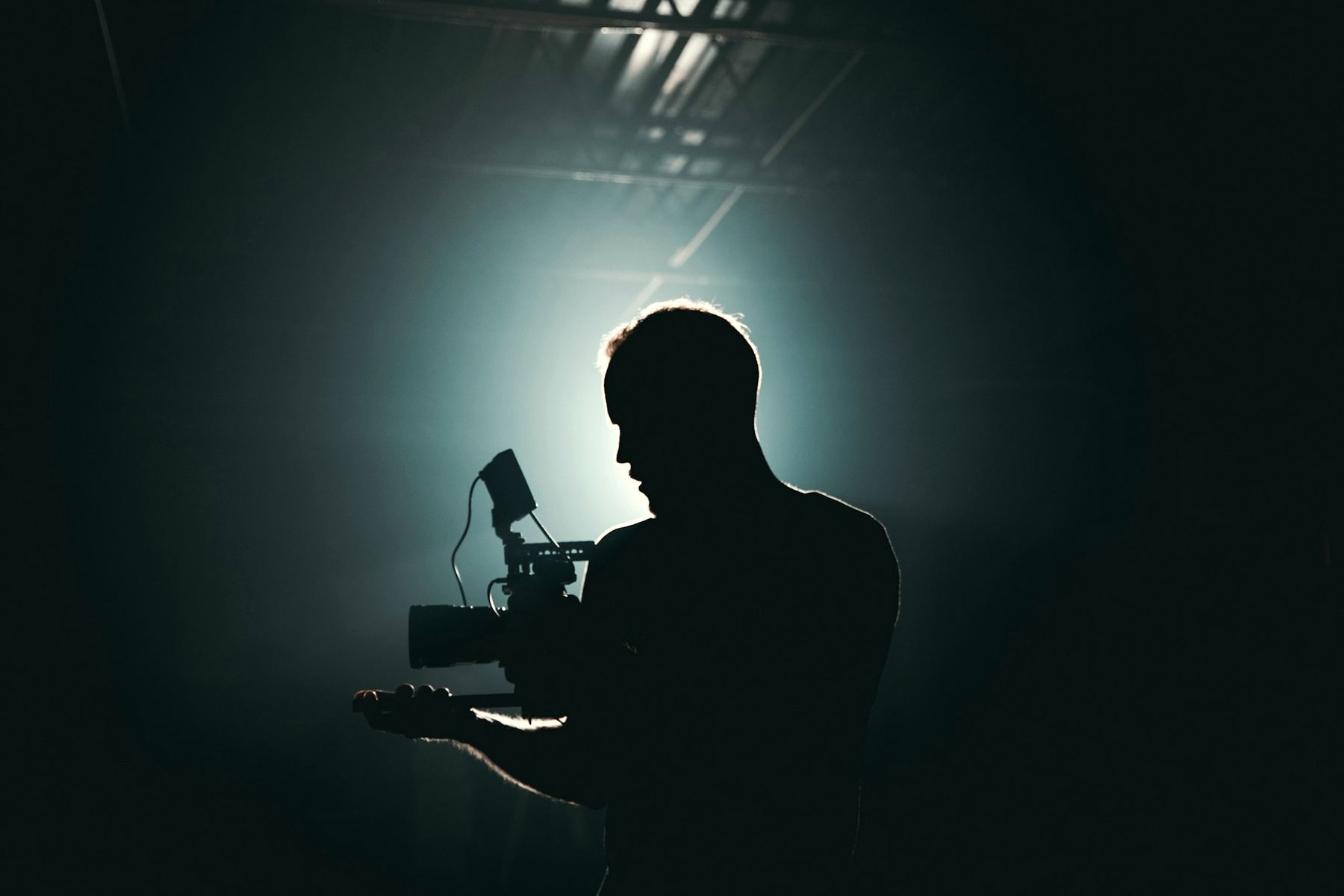 Camera operator silhouetted against a light